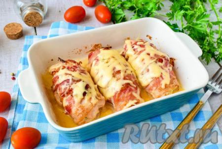 Готовые куриные рулетики с грибами в беконе извлеките из духовки и сразу же горячие посыпьте натёртым сыром. Сыр сразу начнёт плавиться на горячих рулетах.