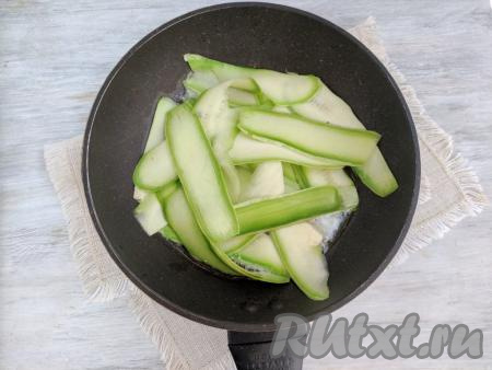 На сковороду выложить сливочное масло, растопить его, затем добавить ленты кабачка, обжаривать 1-2 минуты на среднем огне (до мягкости кабачков), периодически аккуратно перемешивая.