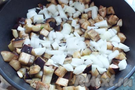 В жаровне (или в сковороде с толстым дном) разогрейте растительное масло, выложите баклажаны и, помешивая, обжарьте на умеренном огне в течение 5-7 минут (за это время баклажаны немного "осядут"), затем добавьте нарезанный лук. Обжаривайте, помешивая, в течение 7-10 минут.