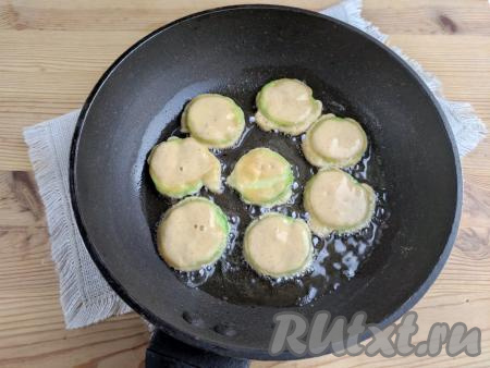 Кабачки, покрытые кляром из кефира, сразу выкладывать в один слой в сковороду, заранее очень хорошо разогретую с растительным маслом. Обжаривать кабачки на среднем огне до получения румяной корочки (на это потребуется 1,5-2 минуты).