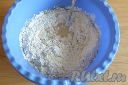 Всыпьте дрожжи с сахаром в молочно-масляную смесь, постепенно добавляя муку, начните замешивать тесто с помощью ложки.