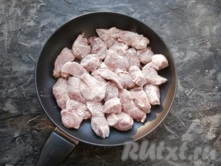 Сковороду хорошо разогреть с 2-3 столовыми ложками растительного масла. Кусочки свинины обвалять со всех сторон в мучной смеси и выложить в сковороду.