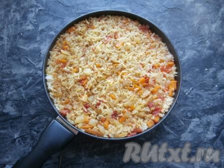 Накрыть сковороду крышкой и готовить рис с баклажанами и помидорами на самом медленном огне около 25 минут. За это время рис должен впитать всю жидкость.