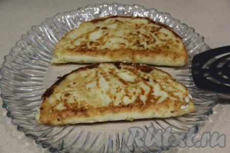 Готовую тортилью из кабачков с начинкой из творога и сыра переложить со сковороды на тарелку. Аналогично сформировать и пожарить ещё 3 тортильи.