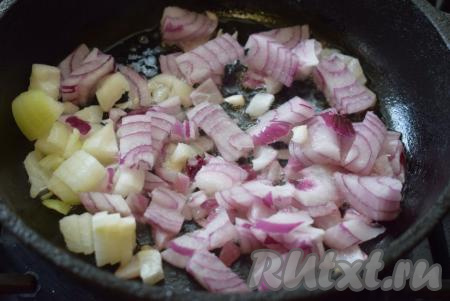 Репчатый лук нарезаем на кубики, выкладываем в сковороду, разогретую  с 2 столовыми ложками растительного масла, и обжариваем, иногда помешивая, на среднем огне до лёгкого подрумянивания лука.