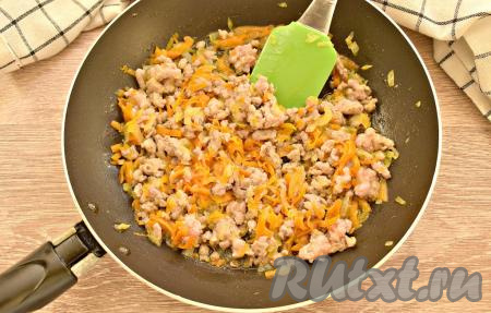 Разбивая кусочки фарша лопаточкой, обжариваем его с морковкой и луком 5 минут. Параллельно включаем духовку и настраиваем температурный режим на 180 градусов.
