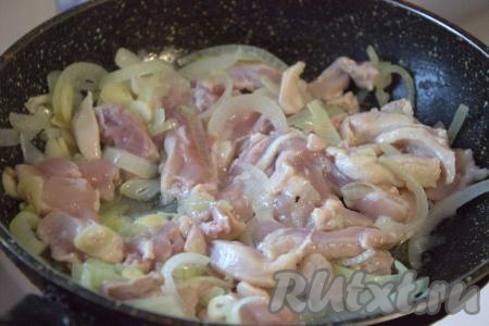Затем к луку с чесноком выложить куриное мясо и на достаточно сильном огне обжарить его до изменения цвета (примерно, 2-3 минуты), помешивая, слегка посолить.
