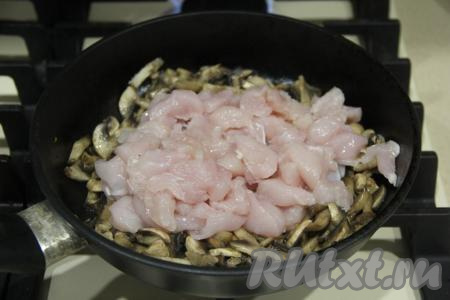 Затем к обжаренным шампиньонам добавить кусочки куриного филе.