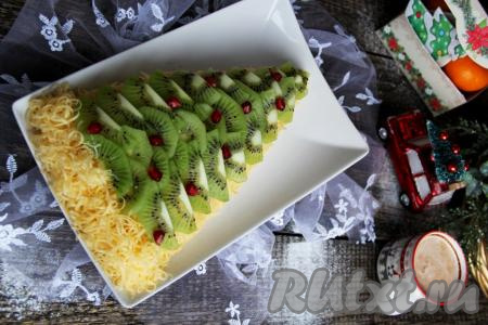 Сытному, очень вкусному, нарядному салату "Ёлочка", приготовленному с киви и курицей, дать пропитаться пару часиков в холодильнике и можно подавать к праздничному столу.