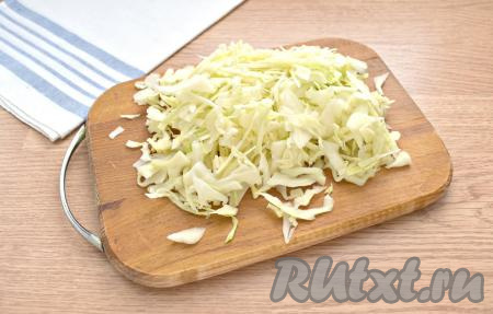 ​​​​​Кастрюлю с бульоном ​​​​​и кусочками свинины ставим на огонь, солим по вкусу, даём бульону закипеть. С белокочанной капусты удаляем верхние листы. Нарезаем капусту на достаточно тонкие полоски и перекладываем в закипевший бульон.