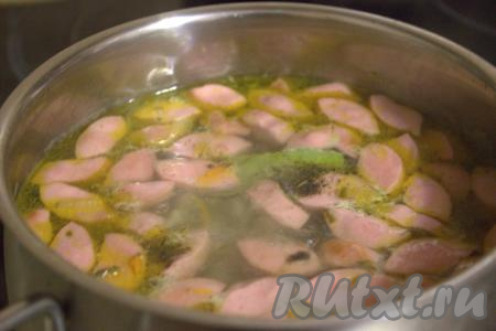 В рассольник с сосисками и солёными огурцами добавить лавровый лист, специи, при необходимости, присолить, довести до кипения и, уменьшив огонь, варить минут 10. Затем убрать с огня и дать настояться блюду под крышкой 10 минут.