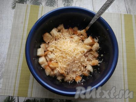 Сухарики перемешать со специями, влить растительное масло с чесноком и снова очень тщательно перемешать. Добавить натёртый на мелкой тёрке сыр.