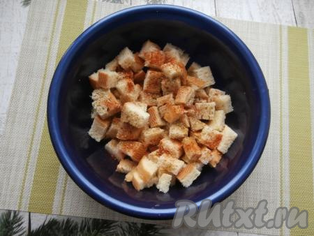 В миску с кусочками батона всыпать соль, ароматные травы, чёрный молотый перец и паприку.