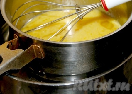 Установить ковшик с яйцами и сахаром над кастрюлей с кипящей водой. Взбивать  на водяной бане в течение примерно 5 минут, пока смесь не станет пенистой.