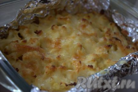 Цветную капусту, запечённую с картошкой под сырной корочкой, можно доставать из духовки и раскладывать по тарелкам.