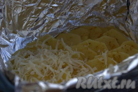 Картошку посыпать любимыми приправами (я использовала универсальную приправу для картофеля). Следующим слоем выложить 1/3 часть натёртого сыра и равномерно распределить по всему картофелю.
