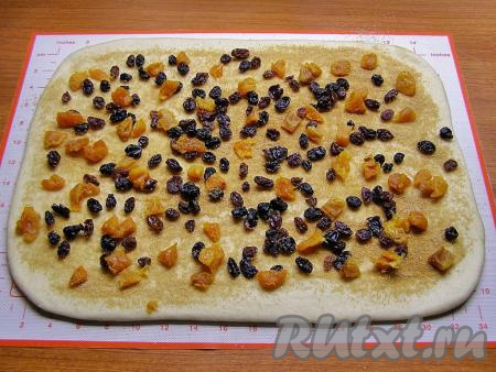 Равномерно выкладываем на тесто изюм с курагой.