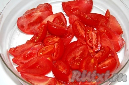 Нарезать помидоры дольками и уложить в миску, в которой красный салат будет подаваться на стол.