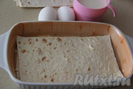 В форму для выпечки (по желанию, предварительно форму можно немного смазать сливочным или растительным маслом) выложить первый отрезанный лист лаваша, немного смазать его с помощью силиконовой кисточки майонезом.