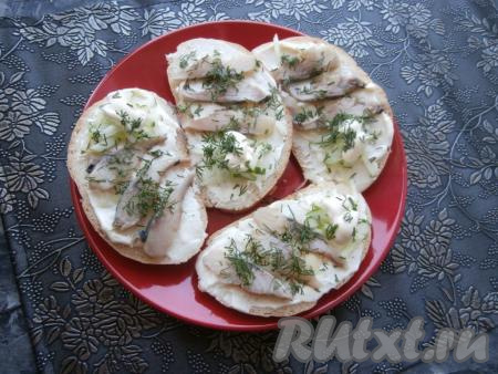 На огурцы капнуть майонезом, посыпать бутерброды измельчённым укропом.