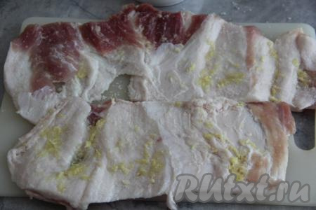 Натереть пласты сала чесноком и солью.