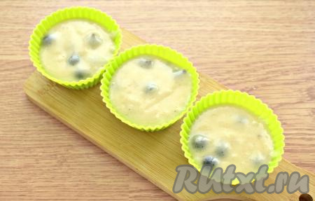 Тесто раскладываем в формочки для маффинов (у меня - силиконовые, смазывать их не нужно). Заполняем формочки тестом на 2/3 объёма, так как во время выпечки тесто будет подниматься. В зависимости от размера формочек получается 12-14 маффинов.