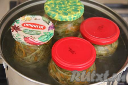 Взять большую кастрюлю, для того чтобы банки в дальнейшем не лопнули в процессе стерилизации, можно на дно кастрюли выложить тряпочку, сложенную в 2-3 раза. Затем поставить в кастрюлю баночки с огурцами и морковью, накрыть предварительно прокипячёнными крышками (я стерилизовала крышки с момента закипания 3 минуты). Влить в кастрюлю с банками с салатом тёплую воду, чтобы она доходила до "плечиков" баночек и поставить на средний огонь.