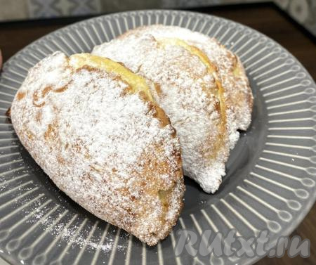 Вкусные, мягкие сочники, приготовленные из теста, замешанного на сметане, с воздушной начинкой из творога достаём из духовки, даём им остыть, а затем посыпаем сахарной пудрой и подаём на стол.