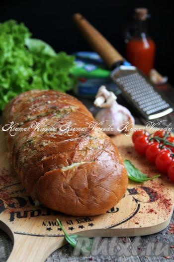 Запечённый фаршированный батон достать из духовки, аккуратно развернуть фольгу. Аппетитный батон с ароматной начинкой из сыра, зелени и чеснока разделить на кусочки и в тёплом виде подать к столу. 