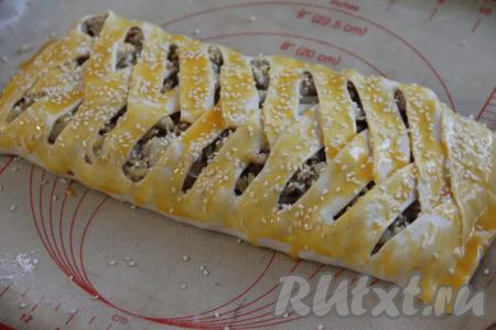 Смазать пирог желтком и, по желанию, присыпать кунжутом.