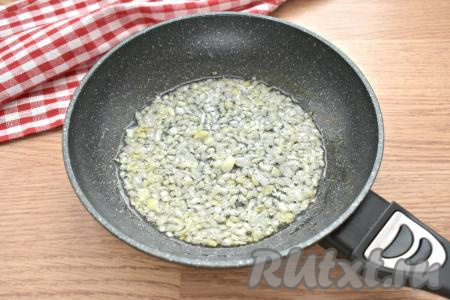 Достаём из морозилки слоёное бездрожжевое тесто, оставляем его размораживаться при комнатной температуре. Очищаем луковицу, нарезаем её на небольшие кусочки и перекладываем на сковороду, уже прогретую с растительным маслом. Обжариваем лук минуты 2-3 на среднем огне, периодически перемешивая.