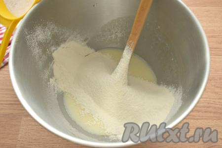 Муку предварительно просеиваем вместе с разрыхлителем. Просеянную муку небольшими частями всыпаем в получившуюся кефирно-яичную смесь, перемешивая тесто с помощью лопатки (или столовой ложки).