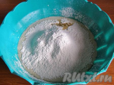 В воду с сахаром и дрожжами добавляем соль и 2 столовых ложки растительного масла, начинаем частями всыпать просеянную муку, перемешивая вначале тесто ложкой.