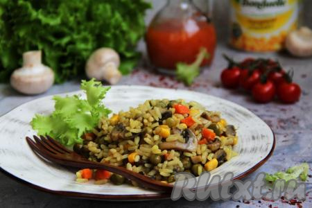 Перед подачей перемешать рис с шампиньонами и овощами, разложить вкусное, яркое, сытное блюдо со сковороды по тарелкам и в горячем виде подать к столу.