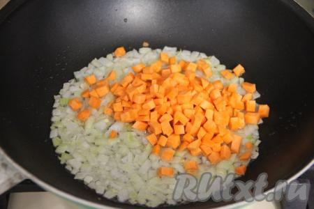 Затем в сковороду добавить морковь, нарезанную на мелкие кубики, перемешать с луком. Обжаривать овощи, периодически перемешивая, минут 5.
