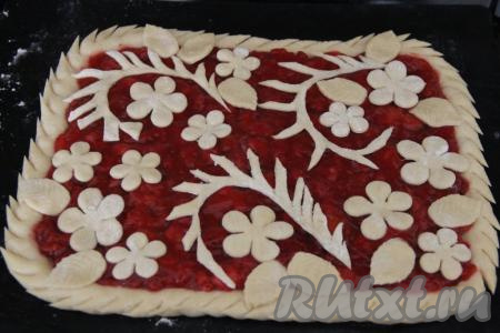 Из оставшейся части теста сделать украшение для пирога (я вырезала цветочки и листики с помощью вырубки для печенья). Вырезанные украшения выложить поверх начинки. Для того чтобы бортики пирога были более интересными, можно сделать на них надрезы.  