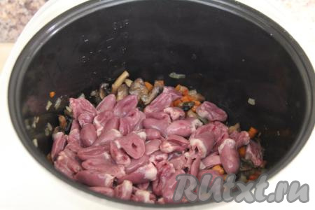 Куриные сердечки промыть, срезать крупные сосуды и разрезать на две части. Добавить сердечки в чашу.