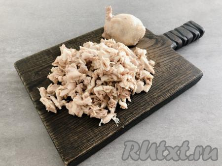 Куриное мясо промываем водой, выкладываем в кастрюлю, заливаем полностью холодной водой, ставим на огонь, а после закипания подсаливаем воду и варим на небольшом огне минут 30 (до готовности), затем достаём из бульона, даём остыть, отделяем от кожи и костей. Для приготовления салата  потребуется грамм 350 варёного куриного мяса без костей. Яйца отвариваем в течение 10 минут после закипания воды, а затем даём им остыть и очищаем. Помидоры моем, даём им немного обсохнуть. Нарезаем мясо курицы на небольшие кусочки.