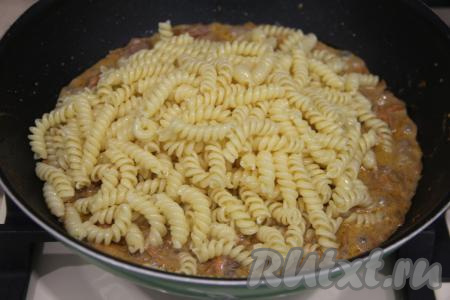 Добавить отваренные макароны в сковороду с куриной печенью, протушившейся в сметане, перемешать.