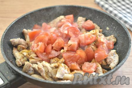 Вымытые помидоры нарезаем на небольшие кубики, добавляем на сковороду, всыпаем специи (у меня - приправа для мяса), перемешиваем, обжариваем свинину с овощами 2 минуты.