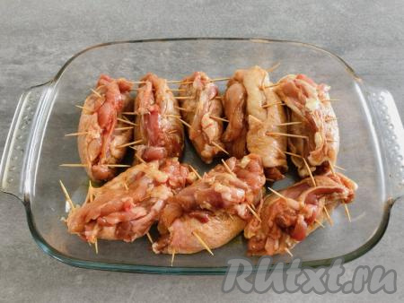 Сформированные рулеты из куриных бёдрышек выкладываем в форму для запекания. Форму перед выкладыванием рулетиков смазывать маслом не нужно, так как растительное масло входит в состав смеси, которую мы наносили на мясо. Рулеты отправляем запекаться в разогретую до 190 градусов духовку на 50 минут.