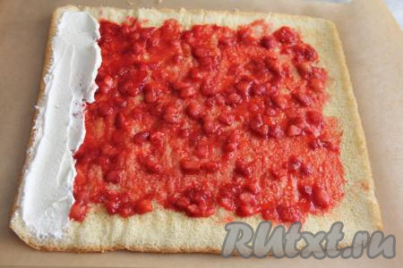 Развернуть корж и смазать остывшей клубничной начинкой, немного отступив от краёв, разровнять.