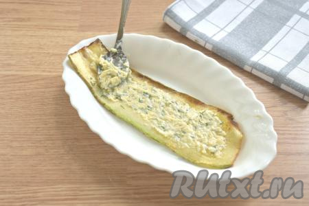 На каждую полоску из кабачка выкладываем примерно 2 чайных ложки сырно-чесночной начинки и равномерно распределяем по всей поверхности.