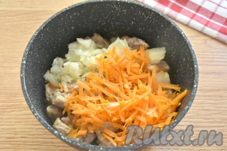 К обжаренным кусочкам свинины добавляем морковку, натёртую на крупной тёрке, и мелко нарезанную луковицу, перемешиваем и обжариваем на среднем огне минут 5, иногда перемешивая.