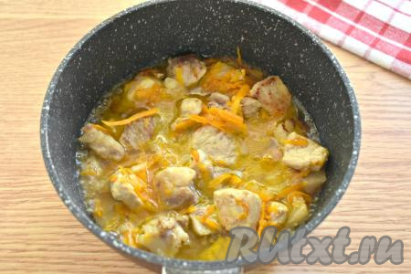 Затем к свинине, обжаренной с овощами, вливаем половину стакана тёплой кипячёной воды, перемешиваем, после закипания воды тушим 10-15 минут на небольшом огне.