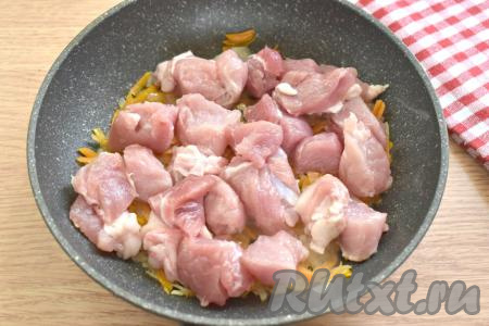 Затем к овощам выкладываем свинину, нарезанную на кубики со стороной 2-3 сантиметра.