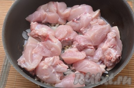 Куриное мясо (у меня грудки без кожи) помыть, порезать на небольшие кусочки, добавить к луку с чесноком. Обжаривать 5 минут.