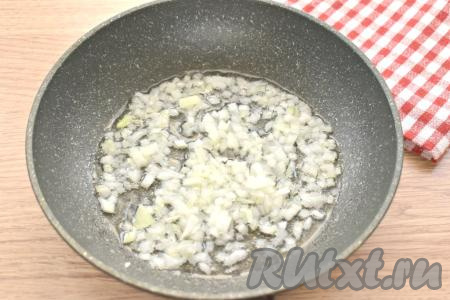 Разогреваем в сковороде растительное масло, выкладываем луковицу, нарезанную мелко. Периодически перемешивая, обжариваем лук на умеренном огне 3-4 минуты (до прозрачности).