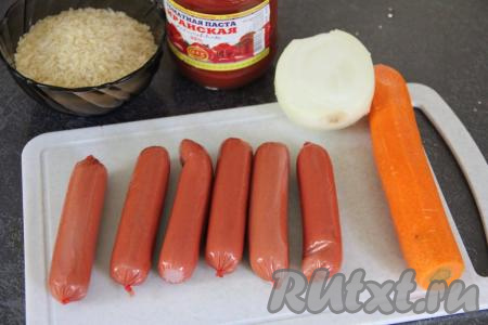 Подготовить продукты для приготовления риса с сосисками на сковороде. Сосиски очистить от слюды. Лук и морковь почистить. Рис выложить в сито и хорошо промыть его водой, а затем дать стечь лишней воде. 