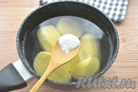 Очищаем картофель, разрезаем его пополам, складываем в кастрюлю, заливаем полностью холодной водой, по вкусу солим и ставим на огонь. После закипания варим картошку до полуготовности (примерно 10-15 минут) на небольшом огне, затем сливаем воду.